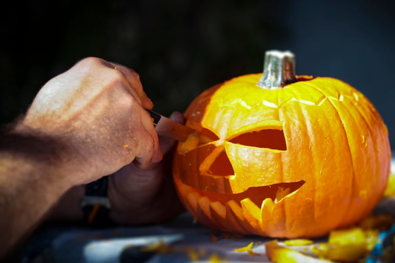 Cortar una calabaza de Halloween.