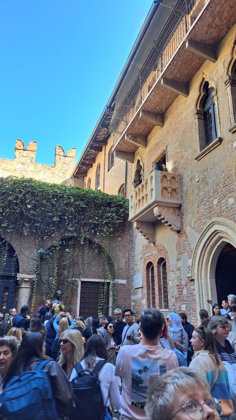 Turistas en el patio de la Casa de Julieta esperando a tomarse una foto con su estatua.