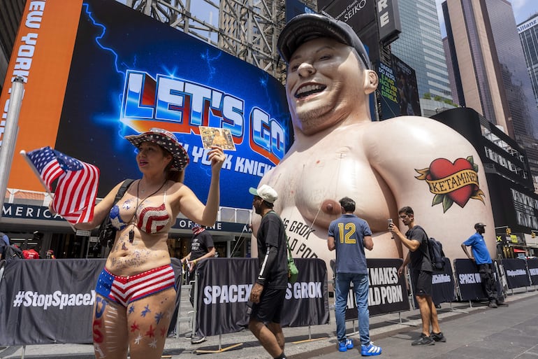 Personas se manifiestan por el lanzamiento a la bolsa de SapaceX frente a un muñeco inflable gigante con la cara de Elon Musk este jueves, en Times Square de Nueva York (EE.UU.). 