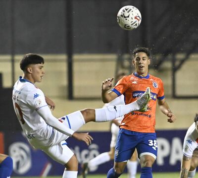 EL delantero de Nacional, Tiago Caballero, despeja el balón ante la presión de Ronald Cornet, volante ofensivo del 2 de Mayo PJC.