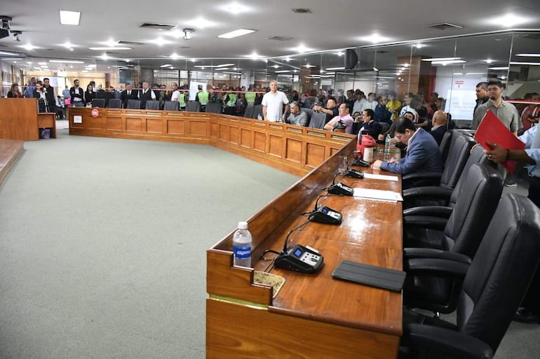 Juan Carlos Ozorio Admen y Miguel Sosa, en un entorno formal, con expresiones tranquilas y felices en sala de deliberación.