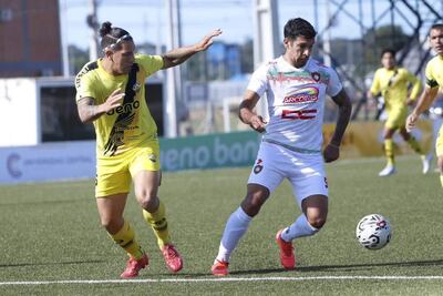 El delantero de Tembetary, Víctor Velazco maneja el esférico ante la presencia del zaguero "canario", Gustavo Villamayor. (Foto: APF)