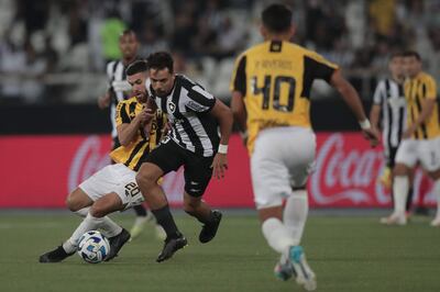 Carlos Eduardo (d), jugador de Botafogo, disputa el balón con Darío Ríos (i), futbolista de Guaraní, en el partido de los octavos de final de la Copa Sudamericana en el estadio Olímpico Nilton Santos, en Río de Janeiro, Brasil.