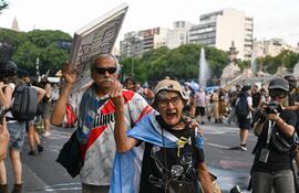 People take part in a protest of trade unionists against the labor reform debate taking place in the National Congress in Buenos Aires on February 11, 2026. Argentine police fired tear gas and used water cannon on February 11 to disperse demonstrators, who threw rocks and firebombs outside Congress during a Senate debate over radical labor reforms. (Photo by Luis ROBAYO / AFP)