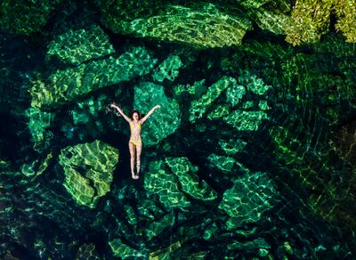 Mujer en las aguas cristalinas de un cenote en México.
