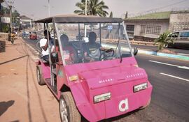El innovador autodidacta James Samba (derecha) conduce un vehículo eléctrico ecológico que fabricó con metales reciclados en Freetown.