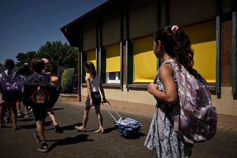 Alumnos salen de la escuela primaria Isle Verte al mediodía, que cierra sus puertas la tarde del 28 y 29 de mayo después de que una ola de calor elevara las temperaturas hasta los 53 °C a comienzos de la semana, en Soustons, suroeste de Francia, el 28 de mayo de 2026.
