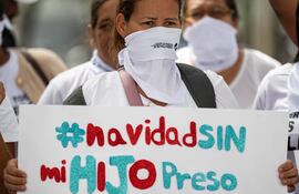 Una mujer sostiene un cartel durante una protesta de Familiares de "presos políticos" frente a la sede del Ministerio Público (Fiscalía), en Caracas (Venezuela).