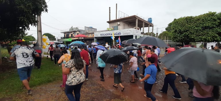 Los devotos caminaron bajo la lluvia con paraguas en mano durante el recorrido de la imagen.
