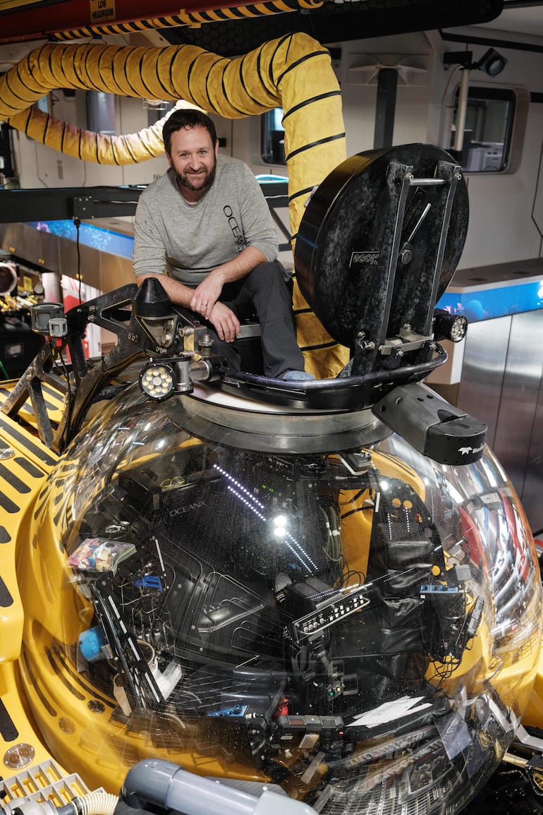 Esta foto, tomada el 10 de enero de 2026, muestra a Dave Pollock, jefe del equipo de sumergibles de OceanX, posando sobre un sumergible dentro del hangar del OceanXplorer, un buque de investigación operado por la organización marina sin fines de lucro OceanX, en aguas frente a la isla de Célebes (Sulawesi).