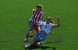 La defensora de la selección paraguaya, Ximena Morena intenta el pase ante la barrida de la delantera uruguaya Oriana Tola.