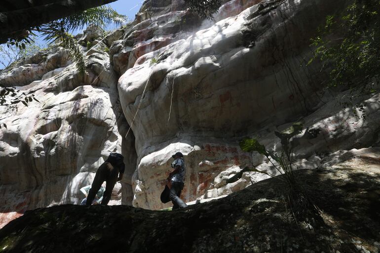 Personas observan pinturas rupestres en la región del Guaviare (Colombia). 