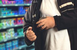 Un hombre sustrae un producto de una tienda.