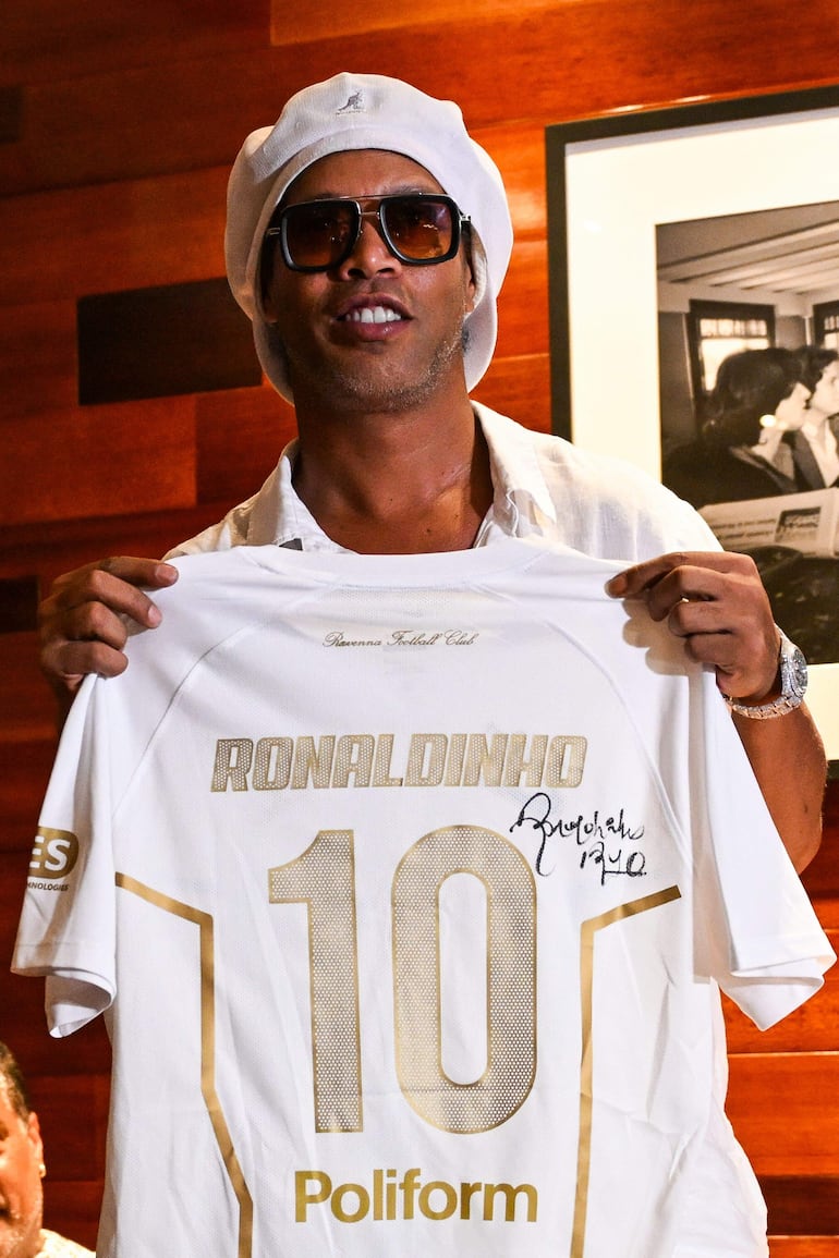 La leyenda del fútbol brasileño Ronaldinho posa con una camiseta firmada durante un evento que marca su presentación como embajador y socio estratégico del club italiano Ravenna FC, en Miami, Florida.