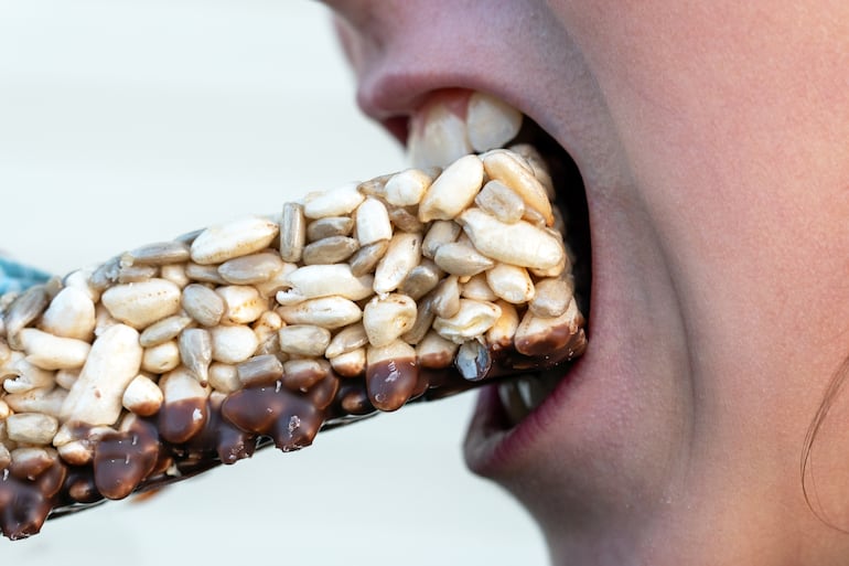 Niño come una barrita de cereales.
