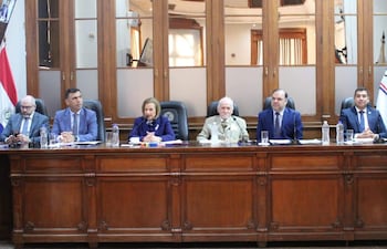 Diego Crispín, Mario Varela y César Garay conversan en mesa larga; Alicia Pucheta habla con atuendo oscuro mientras otros escuchan atentos.