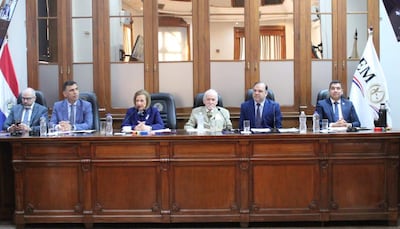 Diego Crispín, Mario Varela y César Garay conversan en mesa larga; Alicia Pucheta habla con atuendo oscuro mientras otros escuchan atentos.