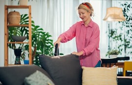Concepto de puttering. Mujer limpiando una zona de la casa.