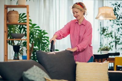 Concepto de puttering. Mujer limpiando una zona de la casa.