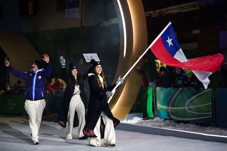 Chile's flag bearer Matilde Schwencke (R) parades with members of the delegation during the opening ceremony of the Milano Cortina 2026 Winter Olympic Games in Cortina d'Ampezzo, northern Italy, on February 6, 2026. (Photo by FRANCK FIFE / AFP)