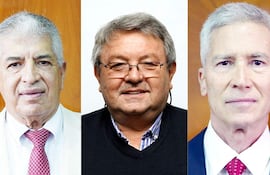 Tres hombres con trajes formales: uno claro con corbata burdeos, otro en suéter negro y el último en traje oscuro con corbata roja, en fondo marrón claro.