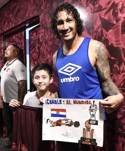 José María Canale posa con un niño fanático de Lanús, que le regaló un poster por su convocatoria a la selección paraguaya.