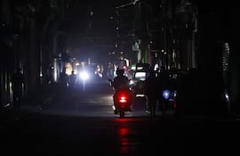 Personas transitan por una calle sin iluminación en La Habana (Cuba).