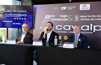 Alonso Chaverri Suárez sostiene micrófono, mientras Ing. Paul Sarubbi y Jorge Sfrir observan en mesa con corbatas distintivas.