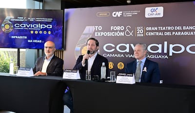 Alonso Chaverri Suárez sostiene micrófono, mientras Ing. Paul Sarubbi y Jorge Sfrir observan en mesa con corbatas distintivas.