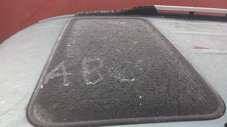 Techo de vehículo cubierto de polvo con inscripción 'ABC', en un entorno frío y cubierto de escarcha.