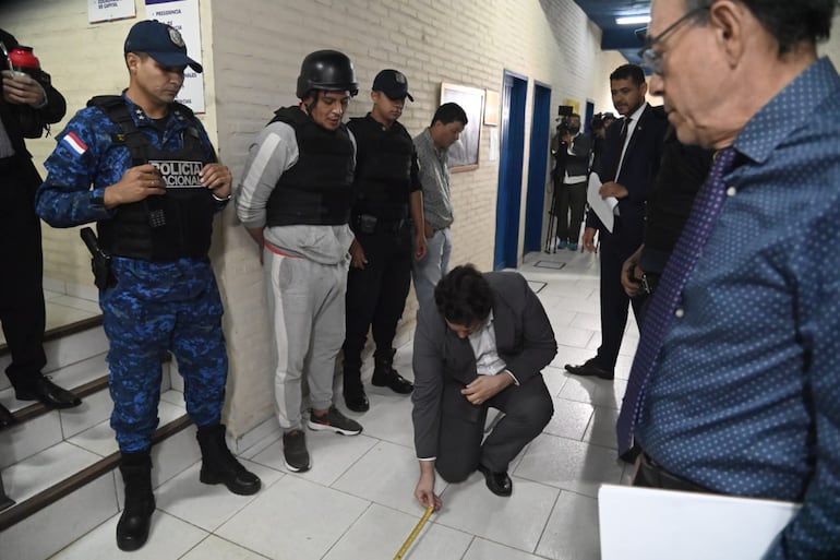 Reconstrucción del asesinato de Rodrigo Quintana en la sede del PLRA. Está presente el suboficial de Policía Gustavo Florentín, esposado, de buzo gris, con chaleco antibala y casco negro.