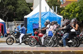 Personas transitan en moto este viernes, en Caracas (Venezuela). Los caraqueños han ido retomando sus rutinas paulatinamente entre el miedo, la tristeza y la nostalgia, al cumplirse un mes del doble terremoto de magnitud 7,2 y 7,5 que afectó la zona norte de Venezuela y que ha dejado un saldo de casi 5.400 fallecidos.
