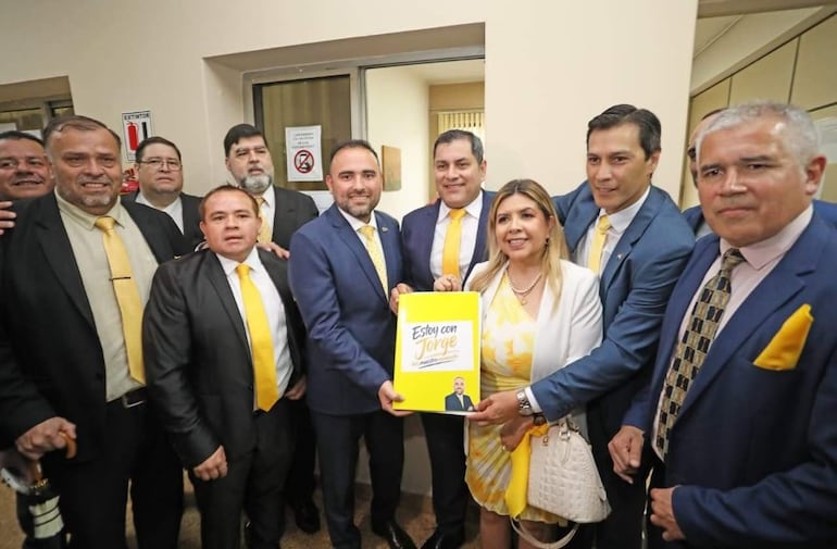 Grupo de candidatos en trajes oscuros y corbatas amarillas, con Jorge Bogarín Alfonso al centro sosteniendo un cartel que dice 'Estoy con Jorge'.