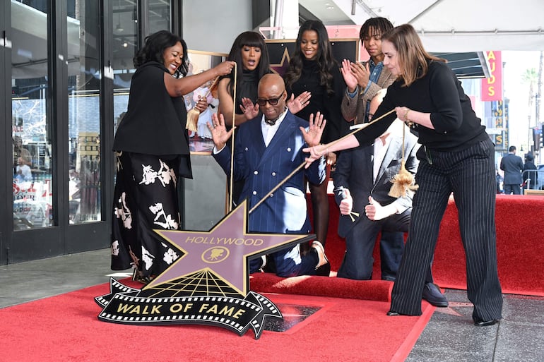 El actor estadounidense Courtney B. Vance reacciona ante la inauguración de su estrella en el Paseo de la Fama de Hollywood, con la periodista de Variety, Angelique Jackson; la actriz estadounidense Angela Bassett, Bronwyn Vance y Slater Vance, el productor John Landgraf y Ana Martínez, vicepresidenta de medios y relaciones con el talento de la Cámara de Comercio de Hollywood. (Robyn Beck / AFP)