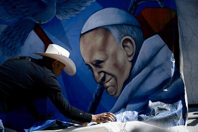 Un artista instala una ilustración del papa Francisco frente al hospital Gemelli, en Roma.
