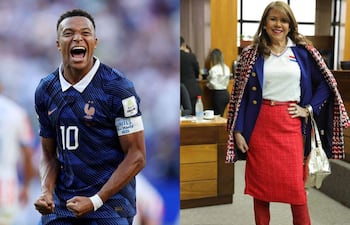 Mbappé en uniforme azul de Francia sonríe junto a mujer con blusa blanca y falda roja, en ambiente interior.