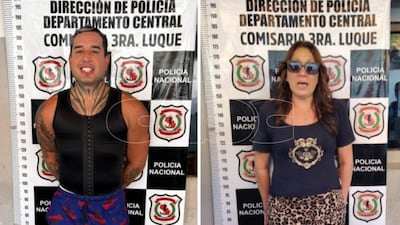 Franccesco Nathannael con camiseta negra y pantalones cortos, sonriente, junto a Josefina con gafas de sol y camiseta negra en comisaría.