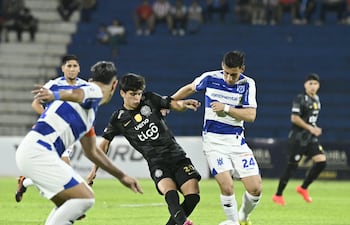 El joven mediapunta de Olimpia, Eduardo Delmás maneja el esférico en medio de las marcas del mediocampista Óscar Romero Adorno y el zaguero Pedro Sosa del Sportivo 2 de Mayo.