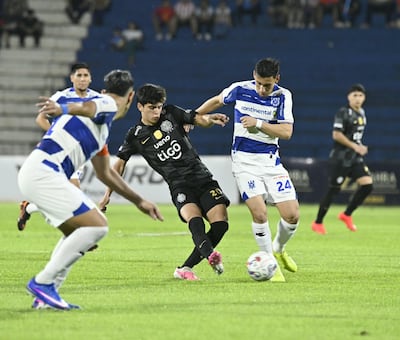 El joven mediapunta de Olimpia, Eduardo Delmás maneja el esférico en medio de las marcas del mediocampista Óscar Romero Adorno y el zaguero Pedro Sosa del Sportivo 2 de Mayo.