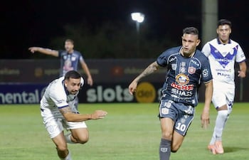 El atacante del Sportivo San Lorenzo Alex “Neymar” Álvarez transporta el esférico ante la marca del lateral izquierdo del Sportivo Ameliano Jesús Abel Paredes.