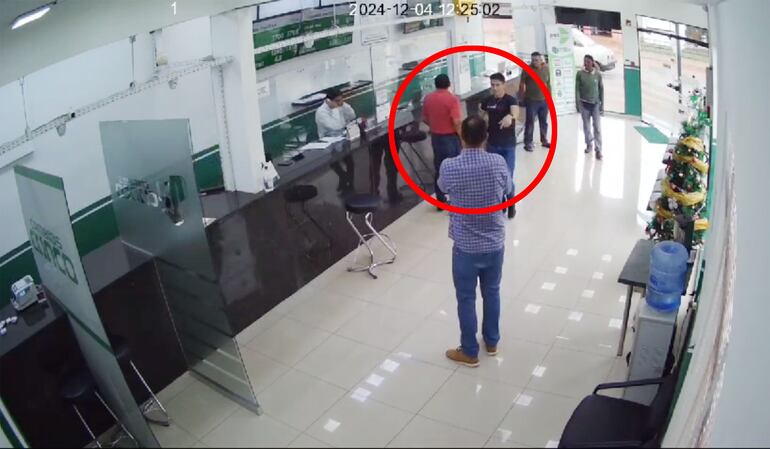 El policía de civil entra a la casa de cambios y pone a salvo a los rehenes.