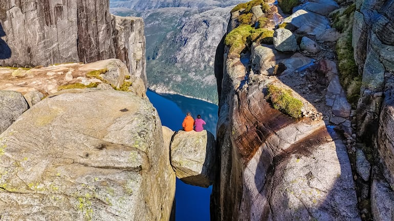 Dos turistas posan en Kjeragbolten, Noruega.