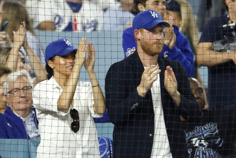 El príncipe Harry, duque de Sussex, y Meghan, duquesa de Sussex, reaccionan durante la quinta entrada del cuarto partido de la Serie Mundial de 2025 entre los Toronto Blue Jays y Los Angeles Dodgers en el Dodger Stadium el 28 de octubre de 2025 en Los Ángeles, California. 