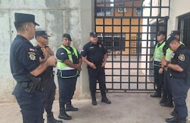 Siete policías, incluyendo un instructor activo, conversan en un entorno de seguridad frente a una reja metálica.