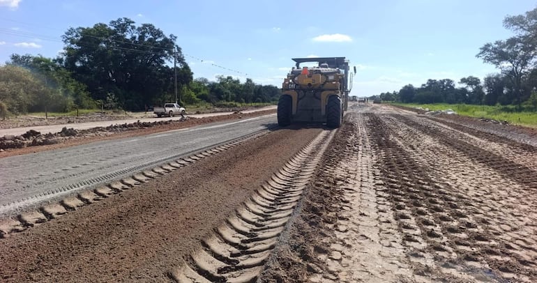 Área de construcción de la ruta PY12 con maquinaria pesada trabajando y vegetación a los lados.