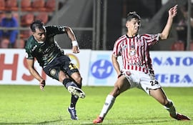 Momento exacto en el que Ángel Cardozo Lucena saca el remate para marcar un golazo esta noche en San Lorenzo, no llega a cubrir Matías Agüero.