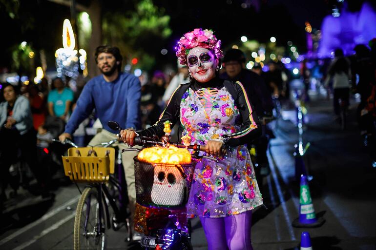 Ciclistas disfrazados participan en un paseo nocturno previo a las celebraciones del Día de Muertos en la Ciudad de México el 25 de octubre de 2025.
