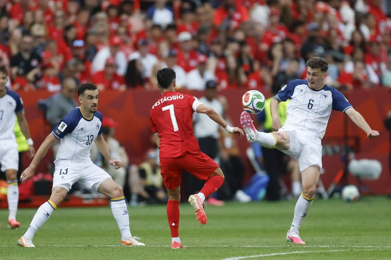 El canadiense Stephen Eustaquio ejerce presión entre Ivan Basic y Benjamin Tahirovic, en una acción del primer tiempo del juego celebrado en Toronto.