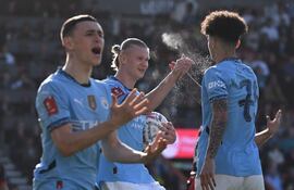TOPSHOT - Manchester City's Norwegian striker #09 Erling Haaland (C) celebrates with Manchester City's English midfielder #75 Nico O'Reilly (R) after the two combine for their first goal during the English FA Cup quarter-final football match between Bournemouth and Manchester City at the Vitality Stadium in Bournemouth, on the south coast of England on March 30, 2025. (Photo by JUSTIN TALLIS / AFP) / RESTRICTED TO EDITORIAL USE. No use with unauthorized audio, video, data, fixture lists, club/league logos or 'live' services. Online in-match use limited to 120 images. An additional 40 images may be used in extra time. No video emulation. Social media in-match use limited to 120 images. An additional 40 images may be used in extra time. No use in betting publications, games or single club/league/player publications. /