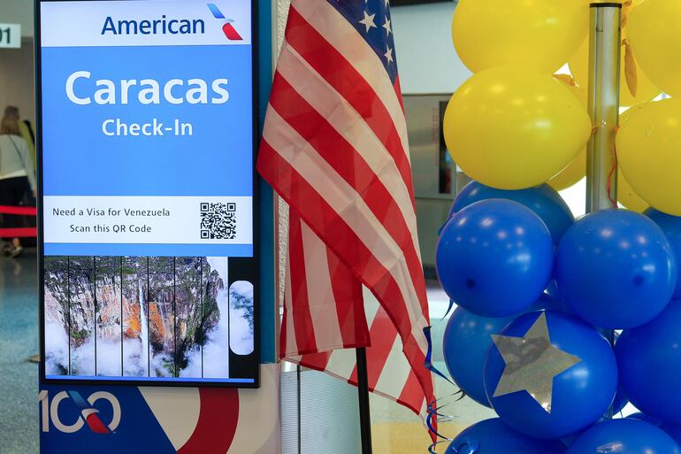 Fotografía que muestra globos con los colores de la bandera venezolana junto a una panel anunciando el vuelo con destino a Caracas ayer, en el aeropuerto Internacional de Miami en Florida (EE.UU.). 